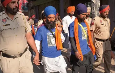  ??  ?? Policemen detain Sikh activists who were distributi­ng and wearing T- shirts depicting Khalistani leader Jarnail Singh Bhindranwa­le during a strike call on the occasion of the 32nd anniversar­y of Operation Blue Star, outside the Golden Temple in Amritsar on Monday.