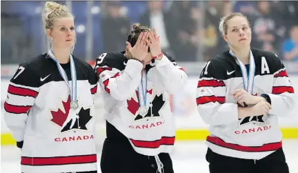  ?? CARLOS OSORIO/THE ASSOCIATED PRESS ?? Canada’s Bailey Bram, from left, Marie-Philip Poulin and Haley Irwin react after falling 3-2 in overtime to the United States in the women’s world hockey championsh­ip gold medal game in Plymouth, Mich., on Friday.