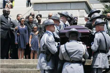  ?? PHOTOS: JOE RAEDLE/GETTY IMAGES ?? As his family looks on, the coffin of South Carolina state Sen. Clementa Pinckney is taken into the South Carolina statehouse on Wednesday.