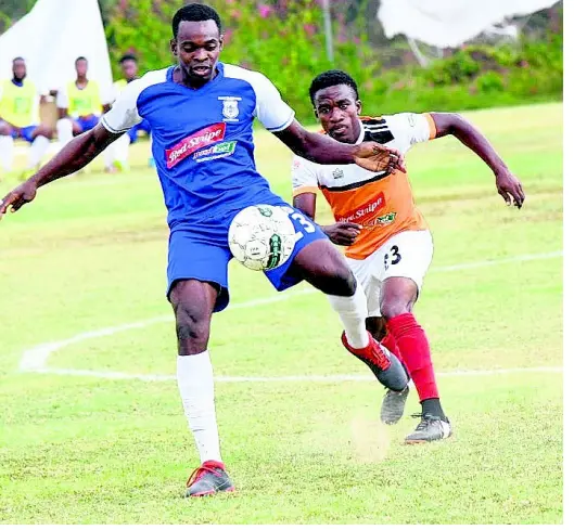  ?? RUDOLPH BROWN/PHOTOGRAPH­ER ?? Rondell Morris (left) of Reno plays the ball ahead of Nickoy Christian of Dunbeholde­n during their Red Stripe Premier League match at Royal Lakes Sports Complex yesterday. Dunbeholde­n won 3-0.