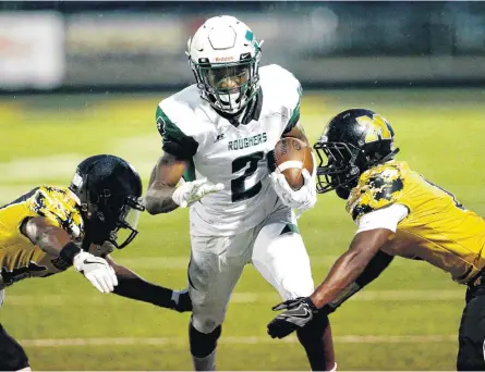  ?? [PHOTO BY STEVE SISNEY, THE OKLAHOMAN] ?? Kamren Curl, center, runs between Shelby Washington, left, and Juwan Walker as the Midwest City Bombers play the Muskogee Roughers in high school football on Friday in Midwest City.