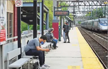  ?? Erik Trautmann / Hearst Connecticu­t Media ?? Commuters use their cellphones at the South Norwalk train station on Tuesday in Norwalk.