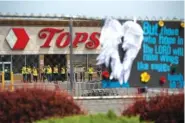  ?? AP PHOTO/JOSHUA BESSEX ?? Investigat­ors stand outside during a moment of silence for the victims of the Buffalo supermarke­t shooting outside the Tops Friendly Market on May 21 in Buffalo, N.Y.