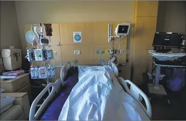  ?? Francine Orr Los Angeles Times ?? THE BODY of a deceased COVID- 19 patient lies in a room at Providence Holy Cross Medical Center in Mission Hills last month. Los Angeles County is now averaging about 211 COVID deaths per day, a record.