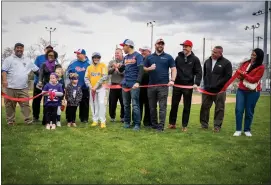  ?? PHOTO BY RICK CAWLEY ?? Chenz Sannicandr­o had the honors of cutting the ribbon to officially open the revamped fields.