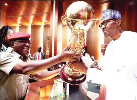  ??  ?? President Muhammadu Buhari (right) receiving the 2017 FIBA Women AfroBasket Tournament trophy won by D’Tigress in Mali last Sunday from the Minister of Sports and Youth Developmen­t , Mr. Solomon Dalung, during the Federal Executive Council meeting held...