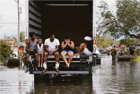  ?? Gerald Herbert / Associated Press ?? Trucks and boats are used to evacuate people from flooded homes in hard-hit LaPlace, La., in the aftermath of Hurricane Ida.