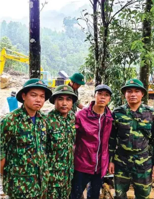  ??  ?? Lieutenant Colonel Tran Hiep Si, who is in charge of the border patrol dogs, with others arrived at Tra Leng landslide scene