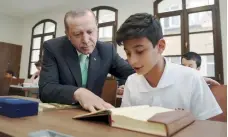  ??  ?? Turkish President Recep Tayyip Erdogan looks on as a student reads the Koran at an Imam Hatip school in Istanbul, in September 2017.