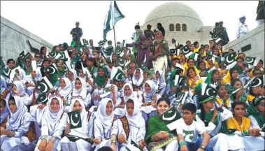  ?? ASIF HASSAN / AFP ?? Pakistani students hold national flags during a ceremony on Monday marking 70 years of independen­ce.