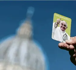  ?? ANGELO CARCONI / EFE ?? Un feligrès amb la imatge del Papa a la plaça vaticana