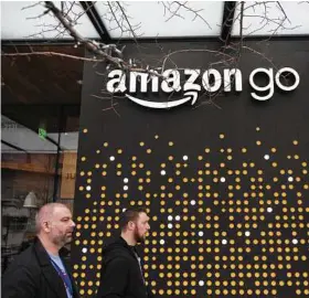  ?? Mike Kane / Bloomberg ?? Pedestrian­s walk past the Amazon Go store in Seattle.