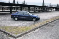  ??  ?? Empty parking spaces in front the Aluminij Mostar aluminium factory in Mostar, Bosnia.