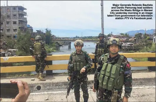  ??  ?? Major Generals Rolando Bautista and Danilo Pamonag lead soldiers across the Masiu Bridge in Marawi City yesterday morning in an image taken from government-run television station PTV 4’s Facebook post.