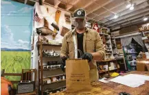  ?? Yi-Chin Lee / Staff photograph­er ?? Manready Mercantile owner Travis Weaver finishes an online order Monday for curbside pickup. Weaver is one of several area retailers who will be open for business Friday.