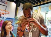  ?? PROVIDED TO CHINA DAILY ?? David Robinson samples some Zongzi, a traditiona­l Chinese food of glutinous rice wrapped in bamboo or reed leaves, during a fan event at the new NBA Championst­hemed FamilyMart shop in Shanghai on Thursday.