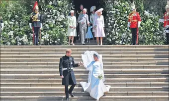  ??  ?? The newlyweds walk hand-in-hand down the steps of St George’s Chapel