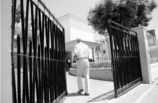  ?? FILE ?? A man walks through the gates of the Ministry of Finance & Planning, home of the Treasury and the seat from which Jamaica’s economic policy is set and managed.