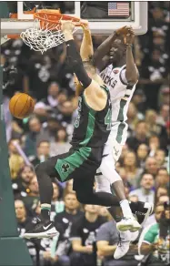  ?? Jonathan Daniel / Getty Images ?? Boston’s Aron Baynes, left, dunks past Thon Maker during Game 4 of their first-round playoff series at the Bradley Center on Sunday in Milwaukee.