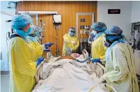  ?? NATHAN DENETTE THE CANADIAN PRESS ?? Health-care workers plan on how to turn a COVID-19 patient in the ICU who is intubated and on a ventilator from his back to his stomach at the Humber River Hospital in Toronto.