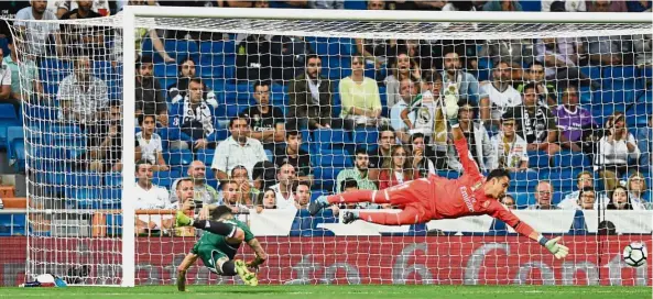  ??  ?? Bravo, Betis!: Real Betis’ Arnaldo Sanabria heading past Real Madrid goalkeeper Keylor Navas in the La Liga match at the Bernabeu on Wednesday. Betis won 1- 0. — AFP