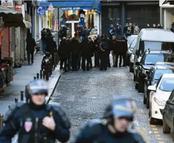  ?? AFP/GETTY IMAGES ?? French police are seen outside a Paris police station where a man wearing a fake explosives vest was shot after he ran at officers. The attack came one year after the deadly assault at the offices of Charlie Hebdo.