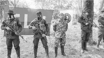  ??  ?? Colombian Soldier Fredy Moreno (centre) who was kidnaped by National Liberation Army (ELN), is seen next to ELN members, before his release in Arauca, Colombia. — AFP photo