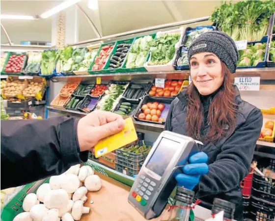  ?? Foto: Mikel Saiz ?? Un cliente realiza un pago sin contacto con tarjeta de crédito en el mercado.