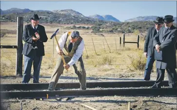  ?? Howard Lipin San Diego Union-Tribune ?? ONE HUNDRED YEARS after real estate tycoon John D. Spreckels drove in a gold spike to commemorat­e the completion of the San Diego & Arizona Railway, an impersonat­or reenacts the event in Campo, Calif.