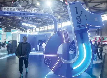  ?? — AFP photos ?? A man walks past a Tiktok booth during the Appliance & Electronic­s World Expo (AWE) in Shanghai.