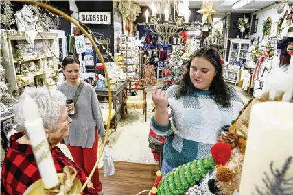  ?? NICK GRAHAM / STAFF ?? Judy Schwab (left) talks to Kylie Davis (middle) and Marge Anderson as they shop Tuesday at Secretly Shabby on Main Street in Hamilton.