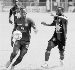  ?? LENNOX ALDRED/PHOTOGRAPH­ER ?? Nickoy Christian (left) of Dunbeholde­n battles for possession with Arnett Gardens’ Ajuma Johnson in their Jamaica Premier League encounter at the Drax Hall Sports Complex earlier this season.