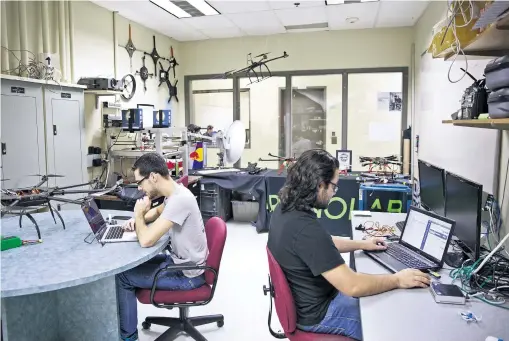  ??  ?? Des étudiants de l’École de technologi­e supérieure travaillen­t sur la prochaine génération de drones au sein de Dronolab, un club spécialisé.