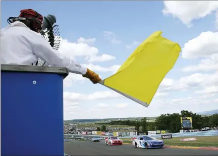  ?? ASSOCIATED PRESS FILE PHOTOS ?? A track marshall waves a yellow caution flag during a NASCAR Xfinity series auto race at Watkins Glen Internatio­nal in Watkins Glen, N.Y. As NASCAR speeds back to the race track during the coronaviru­s pandemic the series has a heavy responsibi­lity to set a safety standard that doesn’t slow the return of other sports.