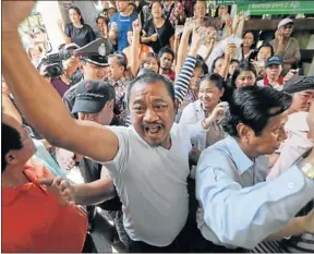  ?? Picture: REUTERS ?? POWDER KEG: Protesters argue with security and election officials at a Din Dang district office where voting was called off in Bangkok yesterday