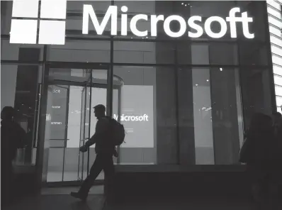  ?? Associated Press ?? ■ People walk past a Microsoft office on Nov. 10, 2016, in New York. China-based government hackers have exploited a bug in Microsoft’s email server software to target U.S. organizati­ons, the company announced March 2.