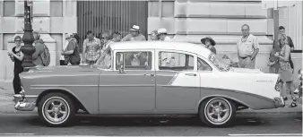  ?? Associated Press ?? ■ In this Feb. 22, 2016, file photo, tourists look at a classic American car parked beside the cruise ship terminal in Havana, Cuba. Cuba is one of four destinatio­ns where a new trip planning company called ViaHero is offering its services. For a flat...