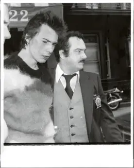  ?? Martha Cooper . Getty Images ?? Sid Vicious escorté par la police (1978).