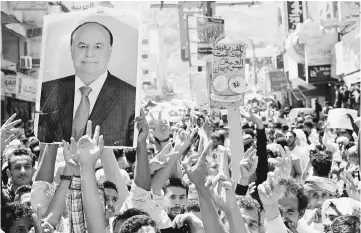  ?? — Reuters photo ?? File photo shows protesters holding up a poster of Mansour Hadi during a protest against the deteriorat­ing economy in Taiz.