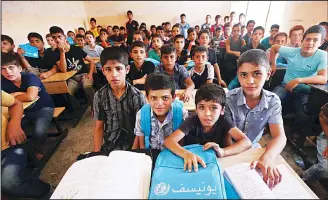  ??  ?? Iraqi boys attend a class at a school in west Mosul on July 27. (AFP)