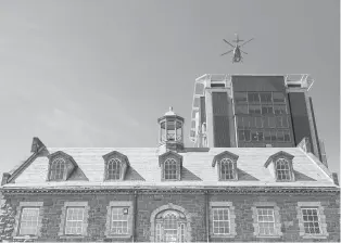  ?? MARK MIRKO PHOTOS/HARTFORD COURANT ?? The century-old Hall-Wilson Laboratory, topped with a slate roof and cupola, is dwarfed by more modern towers on the Hartford Hospital campus.