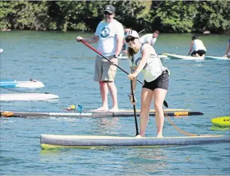  ?? LAURA BARTON
THE WELLAND TRIBUNE ?? In this file photo, Maddi Leblanc smiles as people cheer her and other participan­ts of her stand up paddle boarding fundraiser On Board.