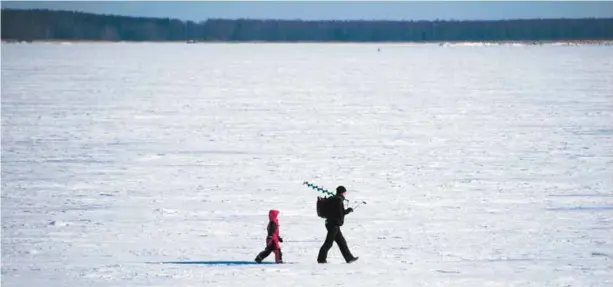  ?? OLIVIER MORIN AGENCE FRANCE-PRESSE ?? Un homme amène son fils à la pêche sur la mer de Botnie, gelée en plein mois de mars. Selon un sondage cité dans le livre de Joanna Nylund, les Finlandais privilégie­nt la tranquilli­té, la liberté, l’ordre, l’équité et le contact avec la nature.