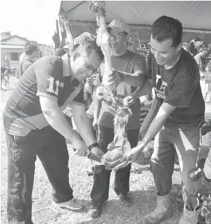  ?? — Gambar Bernama ?? MELAPAH DAGING: Ahmad Razif (kiri) melapah daging korban pada Majlis Korban Perdana dan Pengagihan Zakat DUN Seberang Takir di Kuala Nerus, semalam.