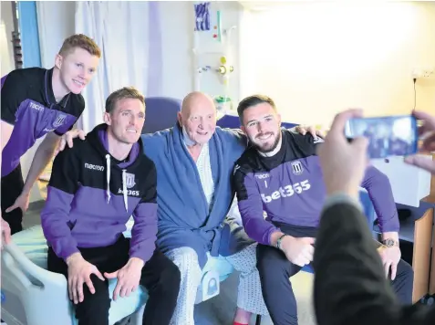  ??  ?? SMILE FOR THE CAMERA: Stoke players Sam Clucas, left, Darren Fletcher, centre, and Jack Butland visited the Royal Stoke University Hospital to hand out presents. The players are posing for a picture with patient Michael Willetts. Picture: Leanne Bagnall