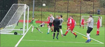  ??  ?? Craig MacEwan, number nine, sends another header wide of the target.