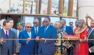  ??  ?? Below, Senegalese President Macky Sall (centre) cuts a ribbon in the colours of the Senegalese flag, surrounded by foreign dignitarie­s, to open the Museum of Black Civilisati­ons.