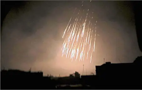  ??  ?? Raining terror: A picture showing what appears to be white phosphorus incendiary rounds descending during a bombardmen­t at Douma in eastern Ghouta. — AFP