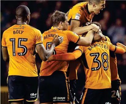  ?? PA ?? Pile on: 20-year-old debutant Oskar Buur Rasmussen is mobbed after his equaliser for Wolves