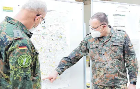  ?? FOTO: ISMAEL AKBAR/BUNDESWEHR ?? Oberst im Generalsta­bsdienst Armin Schaus (rechts) im Gespräch mit einem Mitarbeite­r der Koordinier­ungsstelle für Amtshilfe der Bundeswehr. Schaus führt 16 900 Bundeswehr-Angehörige im Corona-Einsatz und sagt: „Ein Antrag auf Amtshilfe ist leichter auszufülle­n als eine Steuererkl­ärung.“